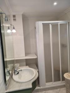 a white bathroom with a shower and a sink at COSTA DAURADA APARTAMENTS - 174 Formentor Luxe II in Salou +10 photos