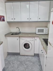 a kitchen with a washing machine and a microwave at COSTA DAURADA APARTAMENTS - 174 Formentor Luxe II in Salou +10 photos