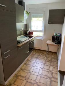 a kitchen with gray cabinets and a tiled floor at Ferienwohnung Siegen Eiserfeld 3 in Siegen