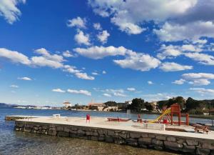 a playground on the beach with a blue sky and clouds at Petra's garden in Kraj +46 photos