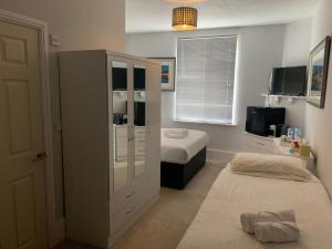 ein Schlafzimmer mit 2 Betten und einem großen Schrank in der Unterkunft Capri Guest House in Torquay
