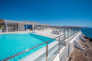 a house with a swimming pool next to the ocean at Etti Paradise Suite Mediterraneo in Pájara