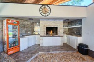 
a kitchen with a fireplace and a large clock on the wall at Apartments & Bungalows Ivanović in Kaštela
