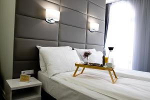 a bedroom with a large bed with a wooden headboard at Plovdiv City Center Hotel in Plovdiv