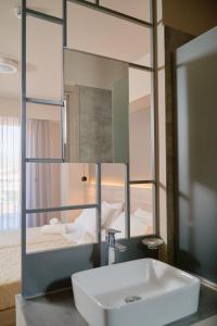 a bathroom with a sink and a mirror at Sunny View Hotel in Kardamaina