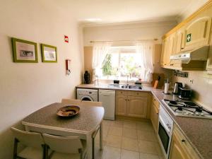 
a kitchen with a stove top oven and a sink at Cool Country Club Apt Portimão in Portimão
