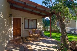 a porch of a house with a wooden pergola at The Garden on Phantom - "Off the grid" in Knysna