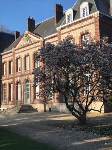 a large brick building with a tree in front of it at CHATEAU D HUGLEVILLE in Hugleville-en-Caux