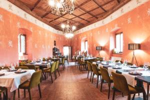 a dining room with tables and chairs and a chandelier at Schloss Freudenstein in Appiano sulla Strada del Vino