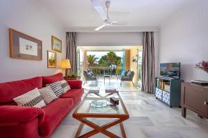 un salon avec un canapé rouge et une table dans l'établissement Las Palmeras Beach with Community Pool, à La Herradura