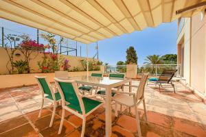 un patio avec une table et des chaises sur un patio dans l'établissement Las Palmeras Beach with Community Pool, à La Herradura