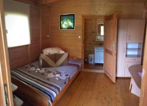 a small room with a bed in a cabin at Kazikówka - Domki letniskowe w Solinie in Solina