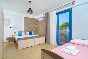 a bedroom with two beds and a balcony at Mikres Kyklades in Skala Potamias