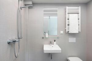 a bathroom with a sink and a shower with a mirror at Lofty Kampus Garnizon in Gdańsk +48 photos