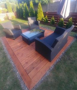 una terrazza in legno con sedie e braciere di Apartament Jantar z ogrodem a Kołobrzeg