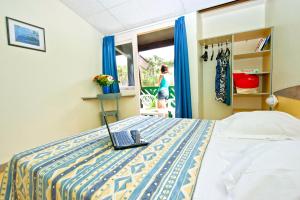 VTF La Forestière في لاكانو-أوسيان: غرفة نوم مع سرير مع لاب توب عليه