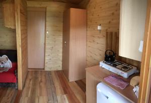 a kitchen with wooden walls and a stove in a room at Kazikówka - Domki letniskowe w Solinie in Solina