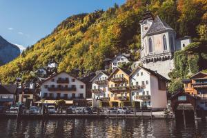 a town on the shore of a lake with a church at Heritage Hotel Hallstatt in Hallstatt