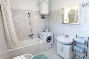 uma casa de banho com uma máquina de lavar roupa e um lavatório em Apartment Gorgo em Secovlje