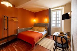 a bedroom with a bed and a table and a television at Le Saint Victor Coeur de Cannes in Cannes
