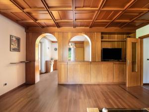 a living room with wooden ceilings and a flat screen tv at Ciasa Soppelsa 2 in Moena