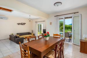 een eetkamer en een woonkamer met een houten tafel bij Apollo Villa in Kolimbia