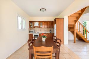 a kitchen and dining room with a table and chairs at Apollo Villa in Kolymbia