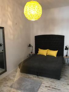 ブダペストにあるVital Apartmentのベッドルーム1室(黒ベッド1台、黄色い枕2つ付)
