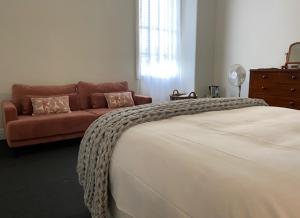 1 dormitorio con 1 cama grande y 1 sofá en The Barkly Bistro Bar & Accommodation en Ararat