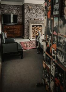 a living room with a fireplace and a television at Elephant Hotel in Pangbourne