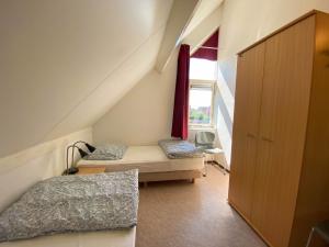 a attic room with two beds and a window at Hello Zeeland - Vakantiehuis Zwin 015 in Breskens