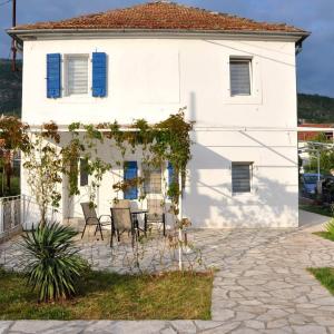 a white house with a table and chairs in front of it at Old marine house in Tivat