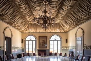 カルデス・デ・モンブイにあるRVHotels Broquetas Spa Termalの椅子とシャンデリア付きの天井が備わる広い客室です。