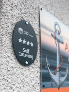 a sign on the side of a building with an anchor at The Anchor Apartments in Ardglass