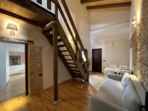 een woonkamer met een trap en een bank bij APARTAMENTOS RURALES POSADA DE LLERENA in Llerena