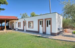 a small white house with a yard at Apartments & Bungalows Ivanović in Kaštela