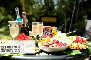 uma mesa com pratos de comida e uma garrafa de champanhe em T&T Scallop em Onna