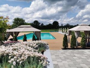 un jardín con sombrillas y una piscina en SHAMBALA WELLNESS CLUB, en Rozhny