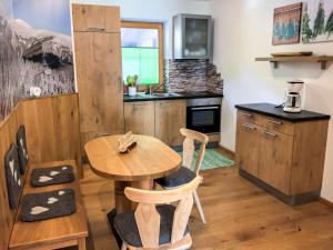 una pequeña cocina con mesa de madera y sillas en Holiday Home Haus Seitner - BMG160 by Interhome, en Mühlbach