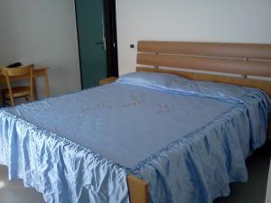 a bed with a blue sheet on top of it at B&B Trento Nord in Trento