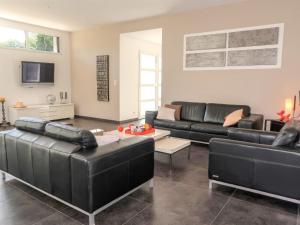 ドゥアルヌネにあるHoliday Home Penn Sardin - DNZ100 by Interhomeのリビングルーム(黒い革張りのソファ、テレビ付)