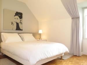 a bedroom with a large white bed and a window at Holiday Home La Marinière by Interhome in Trégunc