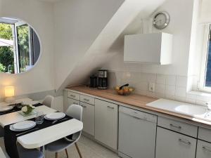 トレガンにあるHoliday Home La Marinière by Interhomeのキッチン(白いキャビネット、テーブル、椅子付)