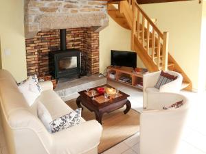 a living room with white furniture and a fireplace at Holiday Home Entre Terre et Mer - PML102 by Interhome in Ploumilliau