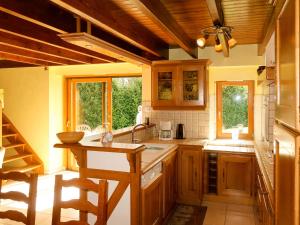 a kitchen with wooden cabinets and a table and chairs at Holiday Home Entre Terre et Mer - PML102 by Interhome in Ploumilliau