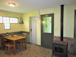 a kitchen with a table and a wood stove at Holiday Home Les Sables - QUE100 by Interhome in Queyrac