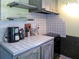 a kitchen with a stove and a counter top at Holiday Home Les Sables - QUE100 by Interhome in Queyrac