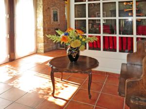eine Vase mit Blumen auf einem Tisch in einem Zimmer in der Unterkunft Holiday Home La Ferme Bis by Interhome in Loctudy