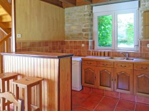 eine Küche mit Holzschränken, einem Waschbecken und einem Fenster in der Unterkunft Holiday Home La Ferme Bis by Interhome in Loctudy