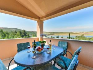 una mesa azul con copas de vino y fruta en el balcón en Apartment Matas - SRD318 by Interhome en Rovanjska